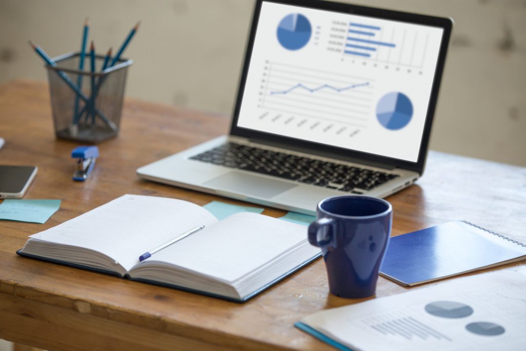 home-office-desk-with-laptop-coffee-mug-notebook-pens