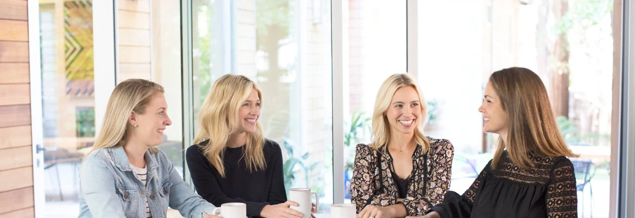 4 women chatting over tea or coffee